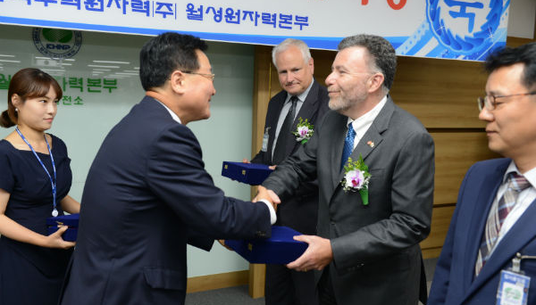 Two men shake hands at ceremony