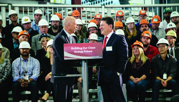 Two men shake hands at podium