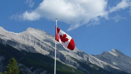 Canadian flag hoisted in front of mountains