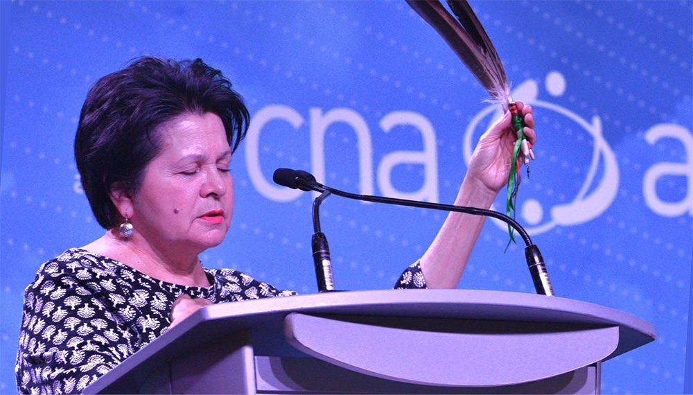 Woman holding feather at podium